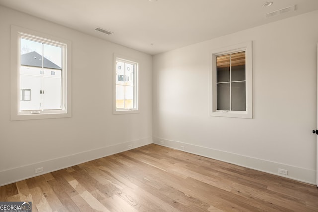 empty room featuring a healthy amount of sunlight and light hardwood / wood-style flooring