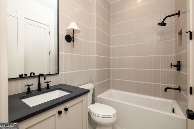 full bathroom featuring tiled shower / bath combo, vanity, and toilet