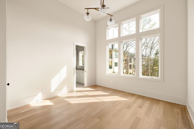 interior space featuring a towering ceiling and light hardwood / wood-style floors