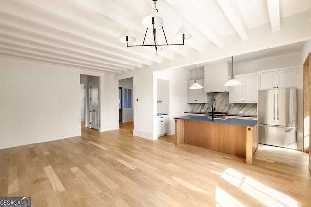 kitchen featuring pendant lighting, an island with sink, white cabinets, decorative backsplash, and high end fridge