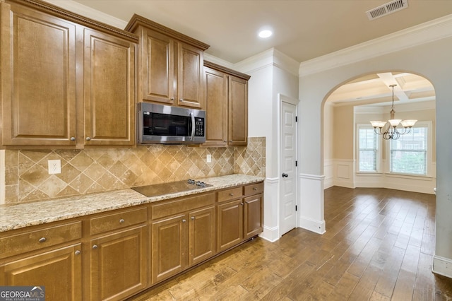 kitchen featuring beam ceiling, a chandelier, hardwood / wood-style flooring, black electric stovetop, and ornamental molding