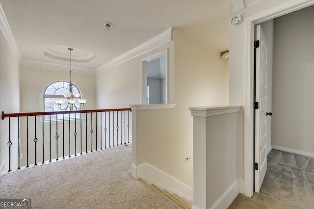 hallway with light colored carpet, crown molding, and a notable chandelier