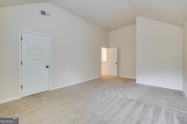 carpeted spare room featuring high vaulted ceiling