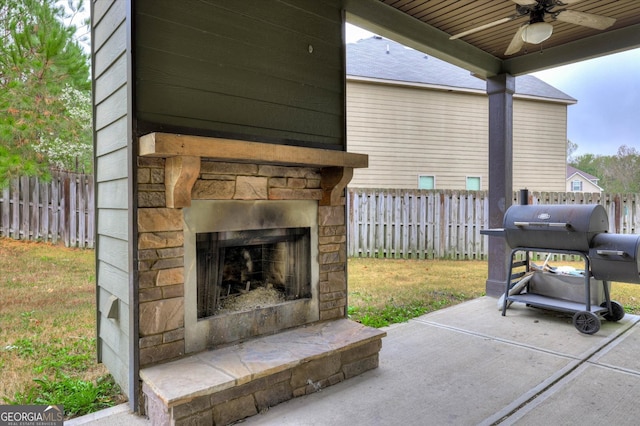 view of patio with grilling area, ceiling fan, and an outdoor stone fireplace