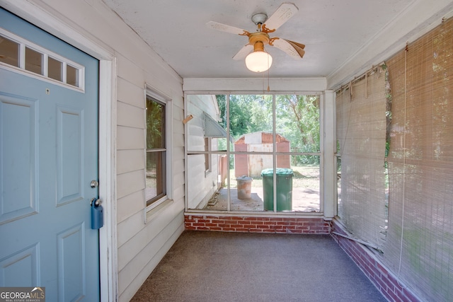 unfurnished sunroom featuring ceiling fan