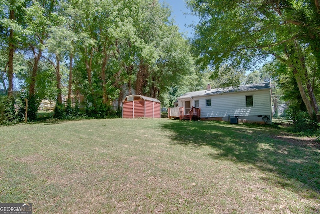 view of yard featuring a deck and a storage shed