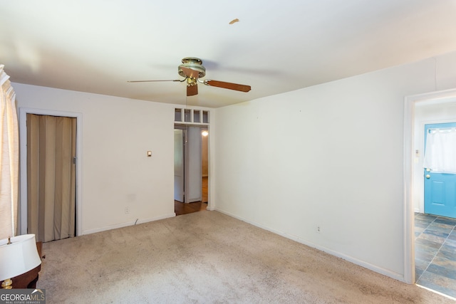 carpeted spare room with ceiling fan