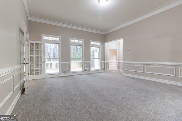 empty room featuring crown molding and carpet floors