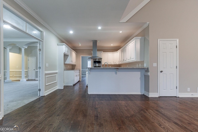 1510 Natchez Way, Grayson, GA 30017 - kitchen with island range hood, decorative columns, a peninsula, white cabinetry, and a sink