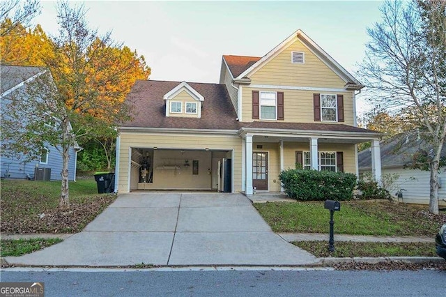 front of property with central air condition unit, covered porch, and a garage