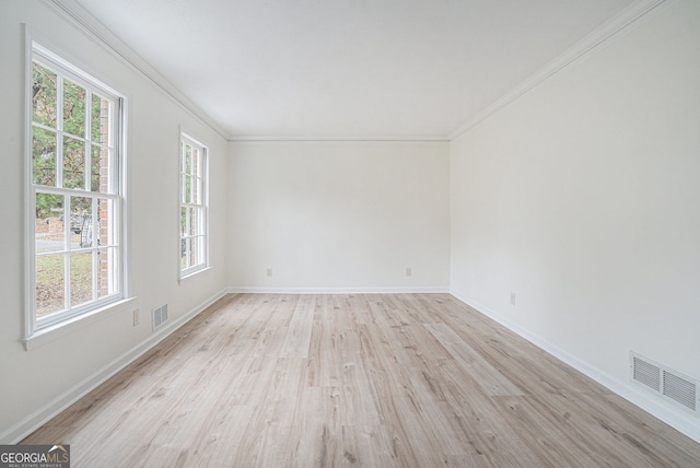 spare room featuring ornamental molding and light wood-type flooring