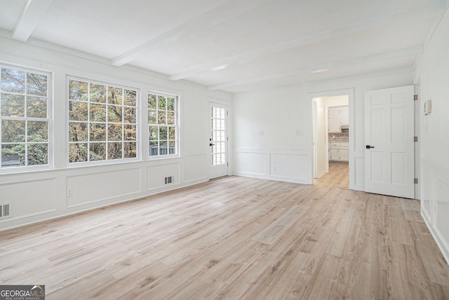 unfurnished room featuring light wood-type flooring and beamed ceiling