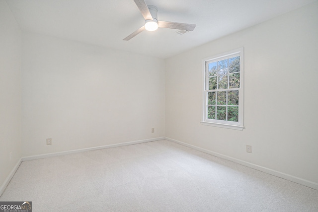 empty room featuring ceiling fan and carpet