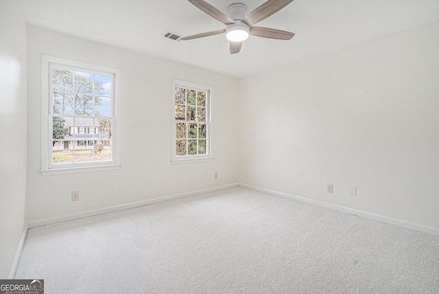 carpeted empty room featuring ceiling fan and plenty of natural light