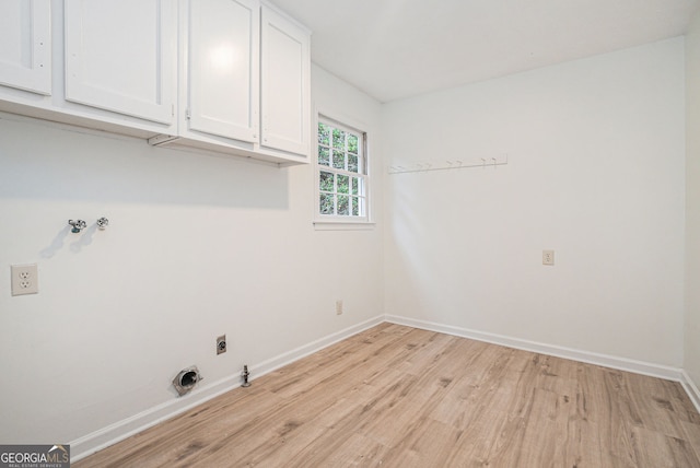 laundry area with light hardwood / wood-style flooring, cabinets, and electric dryer hookup