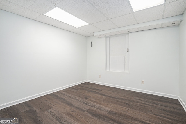 unfurnished room with a drop ceiling and dark hardwood / wood-style flooring