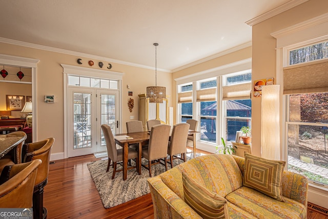 dining area featuring dark hardwood / wood-style floors, ornamental molding, and a wealth of natural light