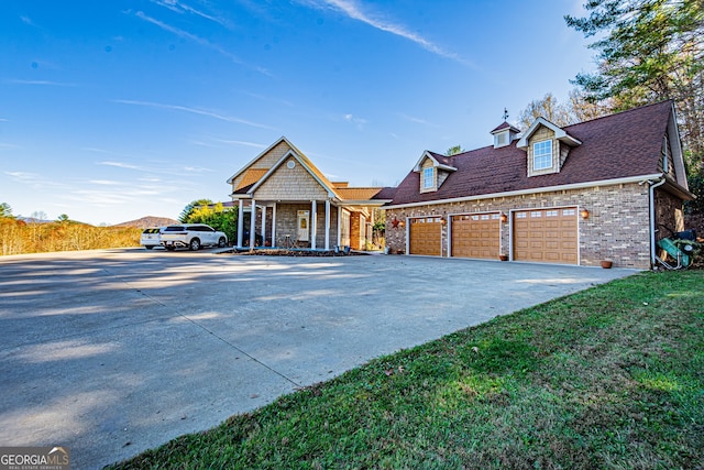 view of front of house with a front yard, a porch, and a garage