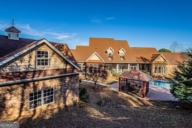 back of house featuring a gazebo and a sunroom