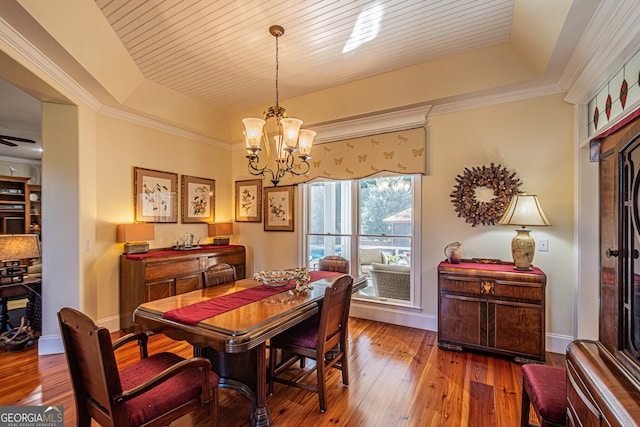 dining area featuring a tray ceiling, hardwood / wood-style floors, and ornamental molding