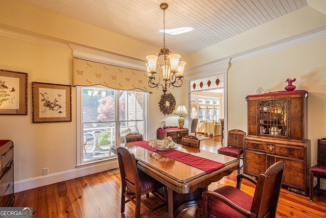 dining room with wooden ceiling, an inviting chandelier, a healthy amount of sunlight, and light hardwood / wood-style floors