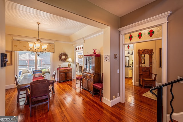 dining room with hardwood / wood-style flooring and a chandelier