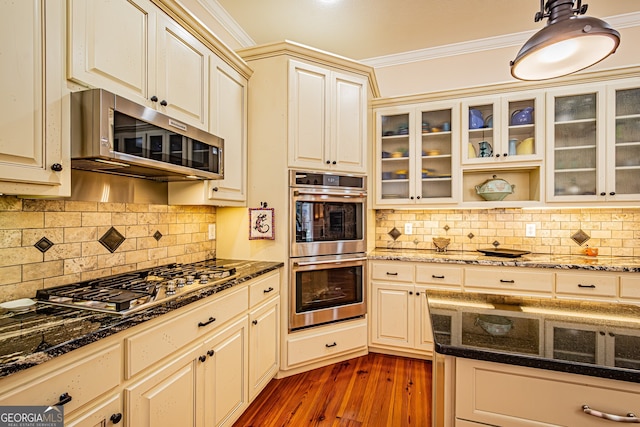 kitchen featuring decorative backsplash, dark hardwood / wood-style flooring, crown molding, and appliances with stainless steel finishes