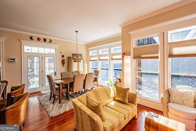 dining space featuring dark wood-type flooring, a healthy amount of sunlight, and ornamental molding