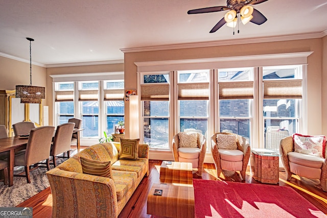 living room featuring hardwood / wood-style floors, ceiling fan, and crown molding