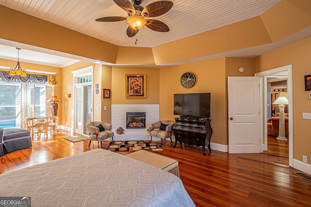 bedroom featuring hardwood / wood-style flooring, a raised ceiling, ceiling fan, and wood ceiling