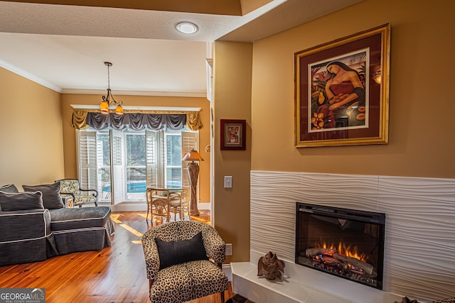 living room with hardwood / wood-style floors, crown molding, and a textured ceiling