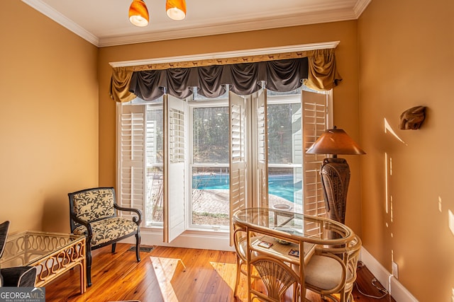 sitting room with crown molding and light wood-type flooring