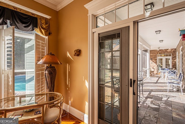 doorway to outside featuring a healthy amount of sunlight and crown molding