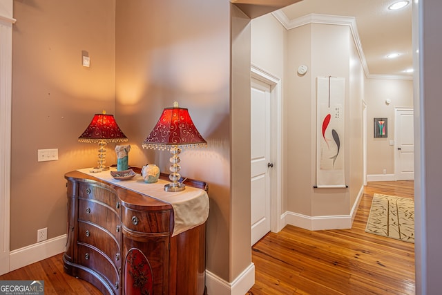 hallway featuring hardwood / wood-style floors and crown molding