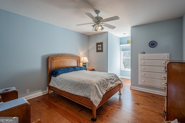 bedroom with ceiling fan, hardwood / wood-style floors, and a textured ceiling