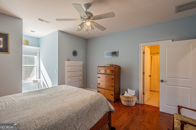 bedroom with ceiling fan, dark hardwood / wood-style flooring, and a textured ceiling