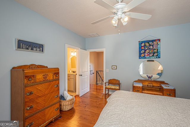 bedroom with ceiling fan, wood-type flooring, and ensuite bath