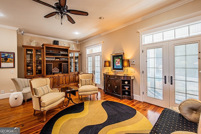 sitting room with hardwood / wood-style flooring, ceiling fan, ornamental molding, and french doors