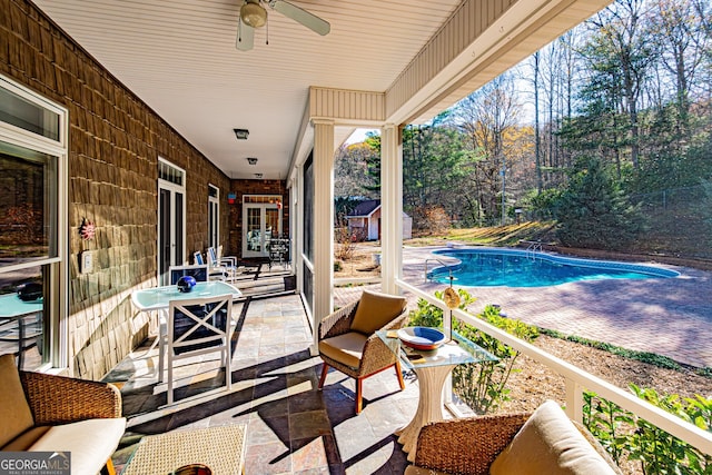 view of swimming pool featuring ceiling fan and a patio