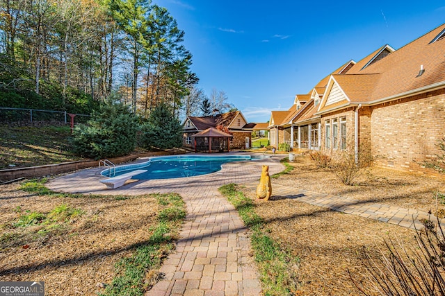 view of swimming pool featuring a gazebo, a diving board, and a patio