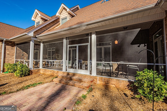 rear view of property featuring a sunroom