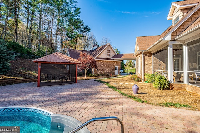 view of pool featuring a gazebo, a patio area, and a sunroom