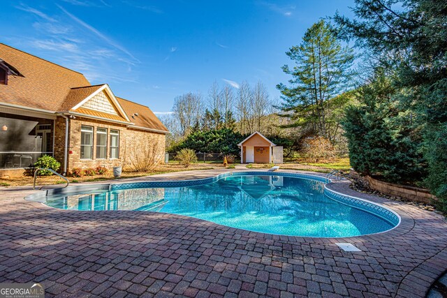 view of swimming pool featuring a storage unit and a patio area