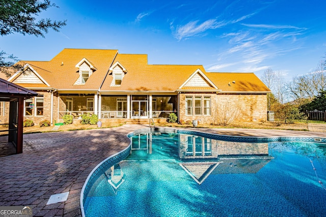 view of swimming pool featuring a patio and a sunroom