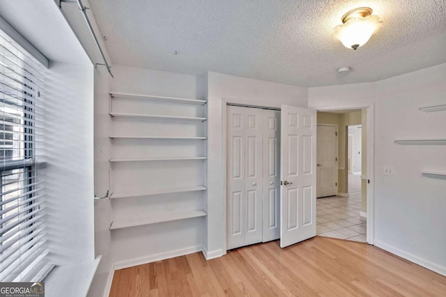 walk in closet with light hardwood / wood-style floors