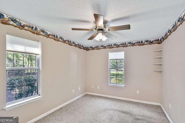 carpeted empty room with ceiling fan, a healthy amount of sunlight, and a textured ceiling