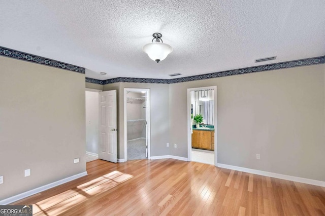 empty room with hardwood / wood-style floors and a textured ceiling