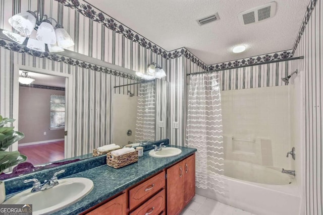 bathroom featuring shower / bath combo with shower curtain, vanity, a textured ceiling, and tile patterned flooring