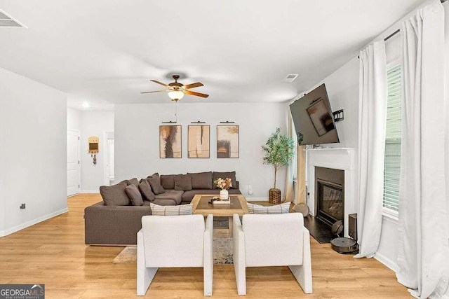 living room featuring light wood-type flooring, plenty of natural light, and ceiling fan