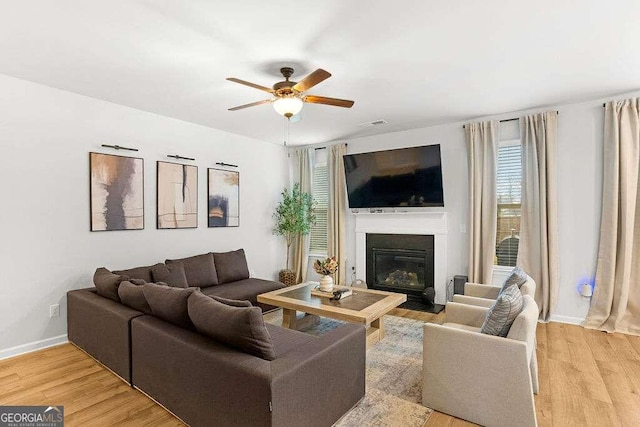 living room featuring ceiling fan and light hardwood / wood-style floors